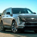 The 2026 Cadillac Escalade IQL showcases its bold front fascia with distinctive vertical LED lighting elements and imposing grille. At 228.5 inches in length, this electric luxury SUV stands as one of the longest production vehicles ever made.