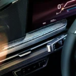 A close-up view of the Escalade IQL's digital display shows the crisp graphics and sophisticated interface. The system displays vehicle information, navigation, and range details, with the vehicle capable of traveling up to 460 miles on a single charge.