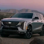 The 2026 Escalade IQL presents an imposing front view at dusk, with its distinctive LED lighting elements creating a dramatic visual signature. Powered by dual electric motors producing up to 750 horsepower, this luxury behemoth can accelerate to 60 mph in just 4.7 seconds.