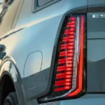 The distinctive vertical LED taillights of the Escalade IQL feature a linear pattern that creates a striking visual signature. The "ESCALADE IQL" badging identifies this as the extended version of Cadillac's flagship electric SUV.