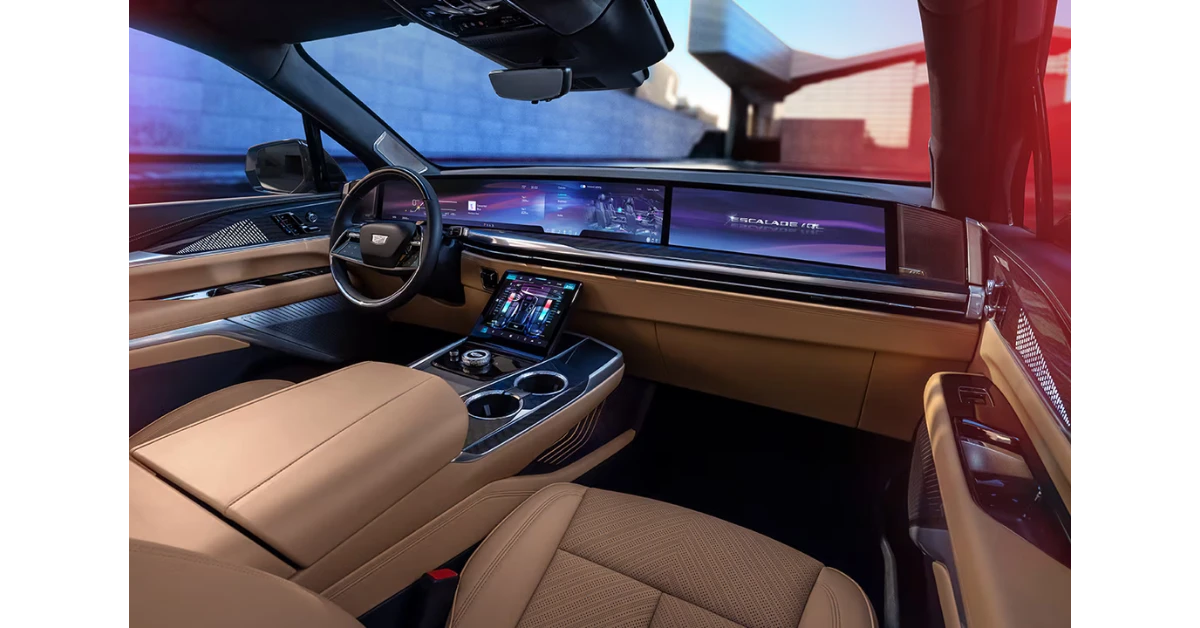 The Escalade IQL's interior is dominated by a magnificent 55-inch curved display that spans the entire dashboard, combining driver information and infotainment in one seamless screen. Shown with premium tan leather interior and high-tech center console.