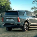 The rear quarter view of the Escalade IQL highlights its more upright back end with the unique triangular C-pillar and more vertical D-pillar, distinguishing it from the standard IQ model. The extended length provides more third-row space and cargo capacity.