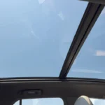 Interior view looking up at the panoramic glass roof of the 2025 Chevrolet Blazer EV, showing the expansive sky view above the passenger cabin.