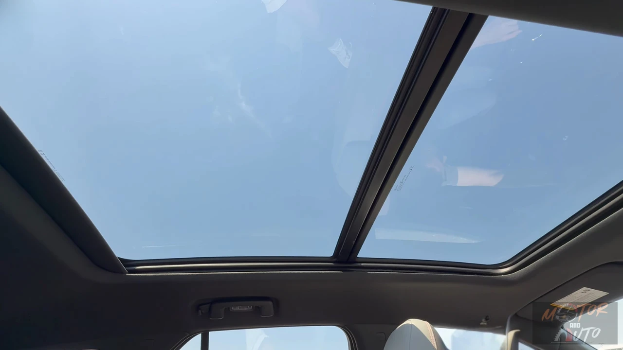 Interior view looking up at the panoramic glass roof of the 2025 Chevrolet Blazer EV, showing the expansive sky view above the passenger cabin.