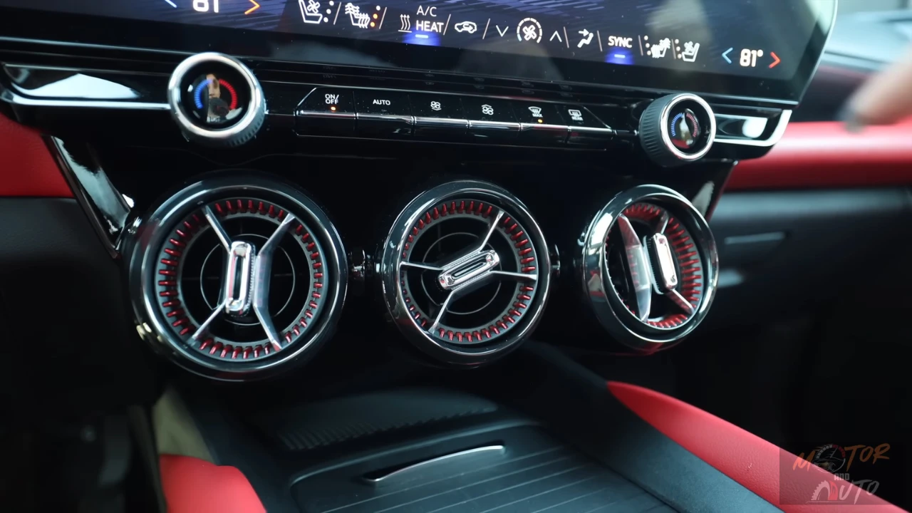 The 2025 Blazer EV features stylish circular air vents with distinctive red accent lighting, chrome detailing, and dedicated physical climate control buttons for easy adjustment.