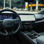 Interior dashboard view of 2025 Chevrolet Blazer EV RS showing dual digital screens, flat-bottom steering wheel with RS badge, and circular air vents with red accents.