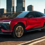 The 2025 Chevrolet Blazer EV SS in motion highlights its athletic stance, dramatic proportions, and aerodynamic design, with up to 21-inch wheels and a two-tone color treatment featuring a black roof and vibrant red body.