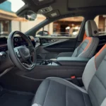 The 2025 Chevrolet Blazer EV SS interior features premium gray and orange-accented seats with a sporty cockpit design, large digital driver display, and a clean modern dashboard layout.