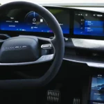 The driver-focused cockpit of the 2025 Lucid Air Sapphire model with its 34-inch curved 5K display showing vehicle information and entertainment options.
