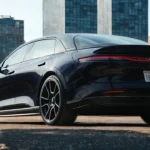 The rear quarter view of the 2025 Lucid Air Sapphire showcasing its premium wheels and distinctive tail light bar. The Sapphire trim represents the pinnacle of Lucid performance with 1234 horsepower and tri-motor configuration.