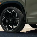 Close-up detail of 2025 Volkswagen Tiguan alloy wheel showing spoke design, Volkswagen center cap, and tire sidewall