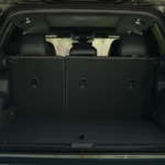 Cargo area of 2025 Volkswagen Tiguan with rear seats up showing storage capacity, tie-down points, and practical loading space