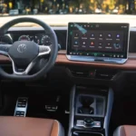 Interior view of 2025 Volkswagen Tiguan dashboard featuring large 15-inch touchscreen, wood trim, leather seats, and premium materials