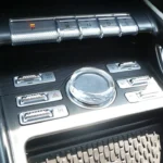 Detailed view of 2025 Lincoln Nautilus center console showing crystal volume knob, premium control buttons, and luxury material finishes