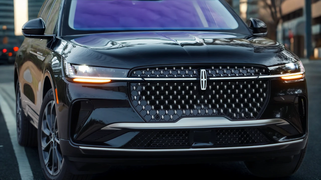 Close-up front view of 2025 Lincoln Nautilus showing diamond mesh grille pattern, LED headlights with amber turn signals, illuminated Lincoln star logo, and premium chrome detailing