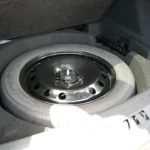 Under-floor cargo area of 2025 Lincoln Nautilus showing full-size spare tire storage and additional compartment space for tools and accessories