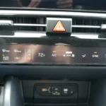 Climate control panel of 2026 Kia Sportage showing dual-zone automatic system with temperature controls, AC, auto climate, sync function, and defrost options