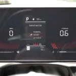 Digital instrument cluster of 2026 Kia Sportage showing drive mode selection menu with Normal, Sport, and My Drive options, fuel gauge, and temperature readings