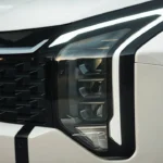 Close-up view of 2026 Kia Sportage front headlight showing new stacked LED design with amber daytime running lights and modern styling elements