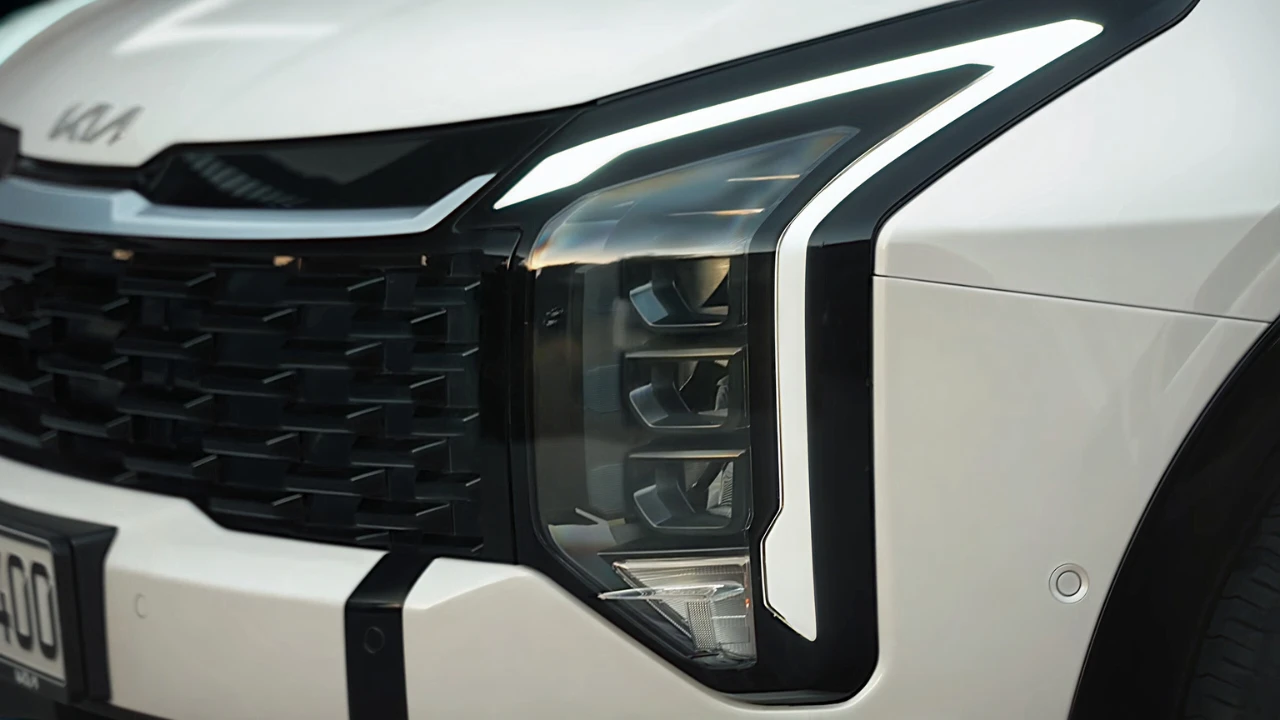 Close-up view of 2026 Kia Sportage front headlight showing new stacked LED design with amber daytime running lights and modern styling elements