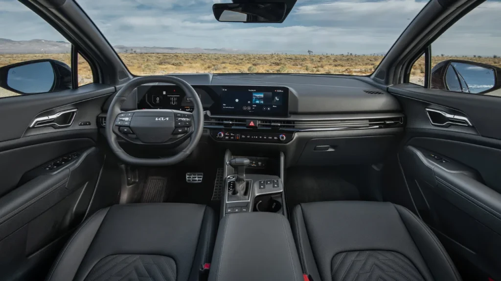 Wide-angle interior view of 2026 Kia Sportage showing complete dashboard, dual 12.3-inch displays, center console, gear shifter, and premium interior appointments