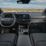 Wide-angle interior view of 2026 Kia Sportage showing complete dashboard, dual 12.3-inch displays, center console, gear shifter, and premium interior appointments