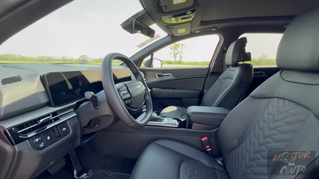Interior view of 2026 Kia Sportage showing new flat-bottom steering wheel, digital gauge cluster, 12.3-inch touchscreen, and premium SynTex leatherette seats with quilted stitching