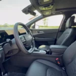 Interior view of 2026 Kia Sportage showing new flat-bottom steering wheel, digital gauge cluster, 12.3-inch touchscreen, and premium SynTex leatherette seats with quilted stitching