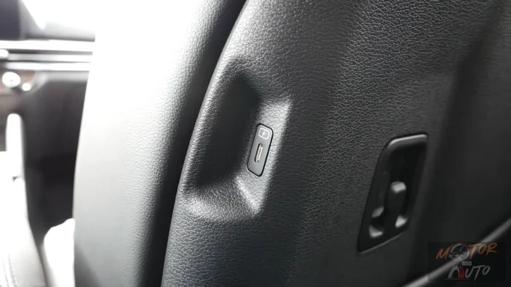 Close-up view of USB-C charging port integrated into front seatback of 2026 Kia Sportage for rear passenger device charging convenience